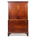 A GEORGIAN OAK CUPBOARD ON CHEST with twin panelled doors above a secretaire drawer, two further