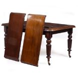 A VICTORIAN MAHOGANY EXTENDING DINING TABLE with reeded legs and brass and ceramic casters, with two