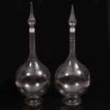 A PAIR OF GLASS PHARMACISTS CARBOYS of globular form with spreading feet and narrow necks, and