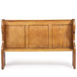 AN OLD PINE SETTLE with arching panel back and shaped ends, 177cm wide x 44cm deep x 117cm high
