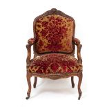 A LATE 19TH CENTURY FAUTEUIL WALNUT OPEN ARMCHAIR with floral decorated overstuffed seat and back