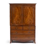 A 19TH CENTURY MAHOGANY LINEN PRESS with twin panelled doors above two short and two long drawers