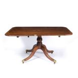 A GEORGE III MAHOGANY TILT TOP DINING TABLE with a turned stem and four sabre legs with brass