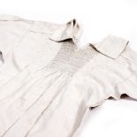 A 19TH CENTURY WORKERS SMOCK with decorative needlework panels, smocked front, back and sleeves,