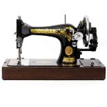 AN OLD SINGER SEWING MACHINE numbered EC357476, 39cm wide x 22cm high in a fitted faux crocodile