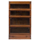 A GLOBE-WERNICKE OAK BOOKCASE with four glazed shelves over a plinth with drawer base, 86cm wide x