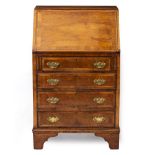 A GEORGE II STYLE WALNUT BUREAU of small proportions, the fall front opens to reveal pigeon holes