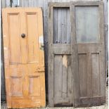 AN IRON AND OAK DOOR with glazed section missing, a pine panelled section, two arts and crafts doors