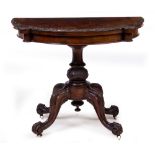 A VICTORIAN WALNUT FOLD OVER CARD TABLE with a later pink baize top, turned support and four