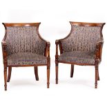 A PAIR OF EMPIRE STYLE DARK STAINED ARMCHAIRS with scrolling arm terminals on columns supports and