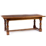 AN 18TH CENTURY STYLE OAK REFECTORY TABLE with turned supports united by stretchers and a