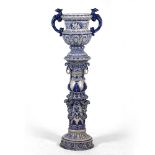 A LATE 19TH CENTURY GERMAN STONEWARE URN and similar stand, decorated in blue, the urn with eagles