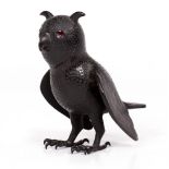 A SMALL BRONZE SCULPTURE depicting an owl with shaped ears and red glass eyes, unsigned, 14.5cm