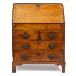 AN 18TH CENTURY OAK BUREAU, the fall front enclosing a fitted interior over drawers and standing