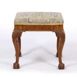 A GEORGE III STYLE WALNUT DRESSING TABLE STOOL with floral needlework overstuffed upholstered seat