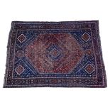 AN OLD SHIRAZ RUST GROUND SMALL CARPET with polychrome expanding diamond decoration within a