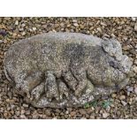 A WEATHERED COMPOSITE STONE CAST SCULPTURE depicting a sow and her piglets, 55cm long snout to tail