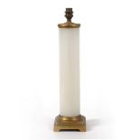 A CYLINDRICAL WHITE GLASS TABLE LAMP with square ormolu base, the base 11.5cm wide, the lamp 45cm