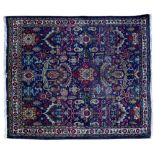 A DARK BLUE GROUND RUG with stylised floral motifs within a central field within a triple banded