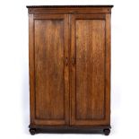 A HARDWOOD CUPBOARD with twin panelled doors enclosing four shelves within, all standing on turned