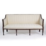 A REGENCY HARDWOOD AND PARCEL GILT SOFA the scrolling terminals to the arms decorated with