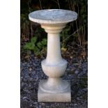 A RECONSTITUTED CAST STONE GARDEN SUN DIAL the circular top with baluster support and on a square