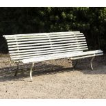 AN OLD GARDEN BENCH with white painted wrought iron supports and slatted seats, 192cm wide x