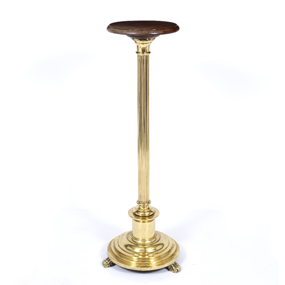 A CIRCULAR MAHOGANY AND BRASS STAND OR TORCHIERE with reeded column, circular spreading base and paw