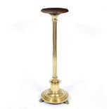 A CIRCULAR MAHOGANY AND BRASS STAND OR TORCHIERE with reeded column, circular spreading base and paw