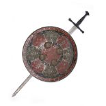 A WHITE METAL INDIAN STYLE CIRCULAR SHIELD with brass bosses and painted red and black, 55cm