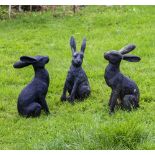 A GROUP OF THREE CAST COMPOSITE RABBIT AND HARE BLACK PAINTED ORNAMENTS approximately 36cm high (3)