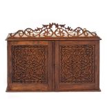 AN ANTIQUE ROSEWOOD WALL CABINET with blind fretwork decorated doors and sides, all beneath a