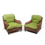 TWO SIMILAR BROWN UPHOLSTERED HOWARD STYLE EDWARDIAN ARMCHAIRS with deep seats, scrolling arms and