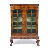 A WALNUT VENEERED BOOKCASE ON STAND IN THE MID 18TH CENTURY STYLE the glazed doors enclosing three