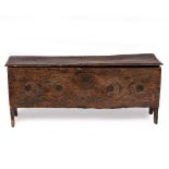 AN ANTIQUE OAK SIX PLANK COFFER with scroll chip carved decoration to the front, 111cm wide x 35cm