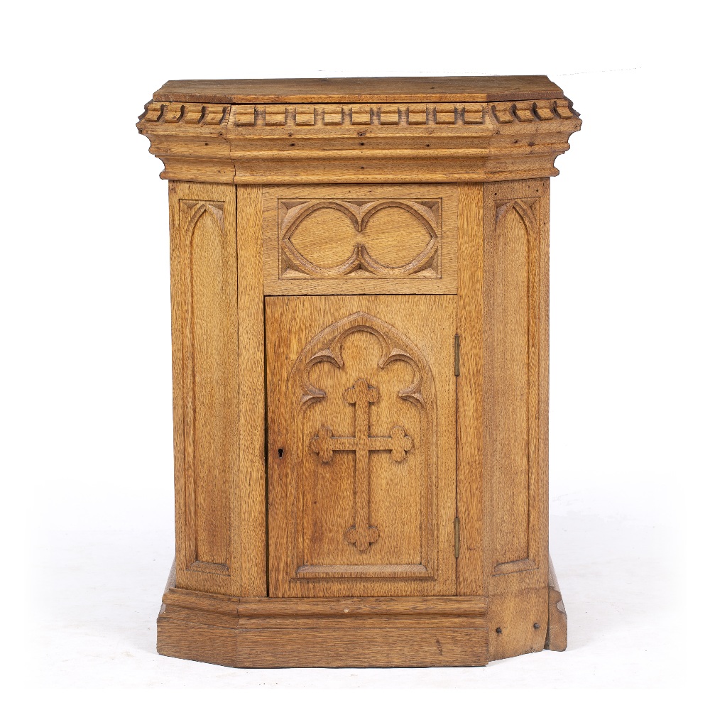 A VICTORIAN OAK GOTHIC REVIVAL PLINTH with castellated top and cupboard to the front, 56cm wide x