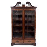 AN ANTIQUE MAHOGANY FLOOR STANDING BOOKCASE with pierced swan neck cresting, astragal glazed doors