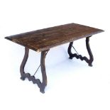 AN ANTIQUE SPANISH CHESTNUT RECTANGULAR TOPPED TRESTLE TABLE with shaped hinged end supports and
