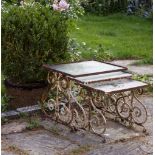 A NEST OF THREE WROUGHT IRON GARDEN TABLES with rectangular glass inset tops and scrolling