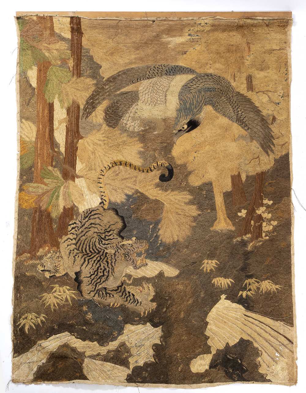 AN ANTIQUE JAPANESE WOVEN PANEL depicting an eagle flying over three tigers in a forest, 136cm