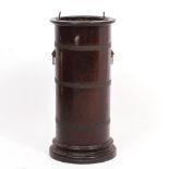 A TURNED MAHOGANY BRASS BOUND CYLINDRICAL STICK STAND with tin liner and lion mask ring handles,