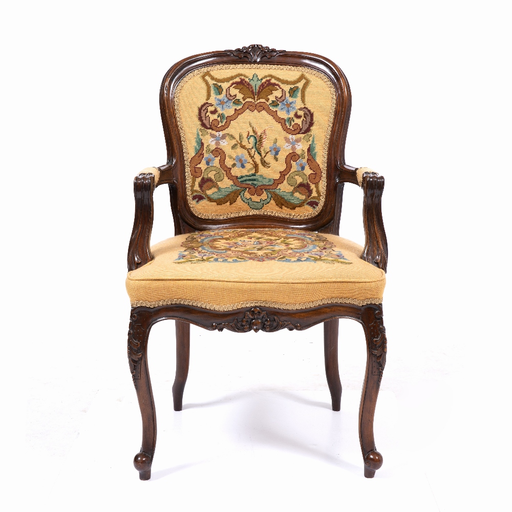 A CONTINENTAL MAHOGANY FAUTEUIL OPEN ARMCHAIR with flower carved cresting rail, needlework