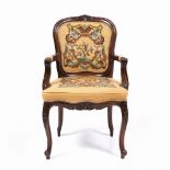 A CONTINENTAL MAHOGANY FAUTEUIL OPEN ARMCHAIR with flower carved cresting rail, needlework