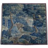 AN 18TH CENTURY FRENCH VERDURE TAPESTRY with cottage nestled in the forest with temple beyond and