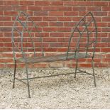A GREEN PAINTED WROUGHT IRON KISSING BENCH with Gothic backs and slatted seat, 94cm wide x 98cm