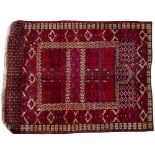 AN ORIENTAL RED GROUND PRAYER MAT with 'V' shaped motifs to the field within a banded border, 155
