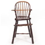 AN ANTIQUE FRUITWOOD SPINDLE BACK CHILD'S HIGH CHAIR with carved saddle seat and turned legs