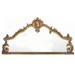 A VICTORIAN GILT GESSO MOULDED OVERMANTLE MIRROR the shaped frame, central crest and decorative