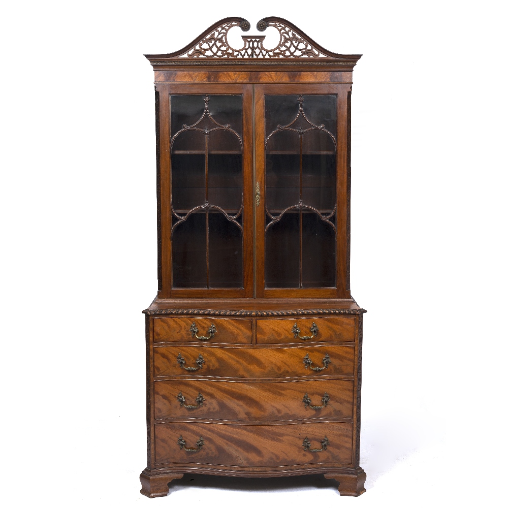 A GEORGE III STYLE MAHOGANY BOOKCASE with pierced fretwork swan neck pediment, astragal glazed doors