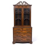 A GEORGE III STYLE MAHOGANY BOOKCASE with pierced fretwork swan neck pediment, astragal glazed doors